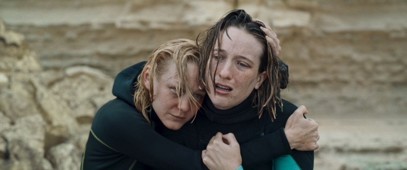 Duas irmãs em roupas de mergulho se abraçam