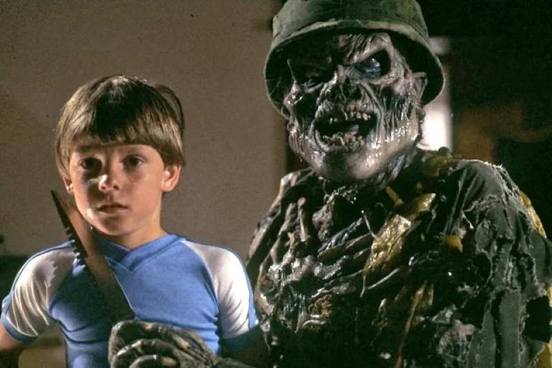 Um menino ao lado de um monstro esqueleto.