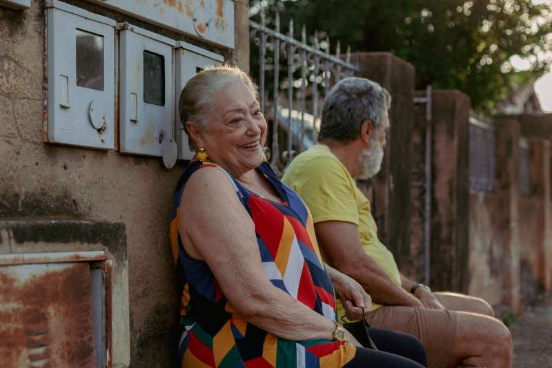 Dois idosos sentados em uma banco.