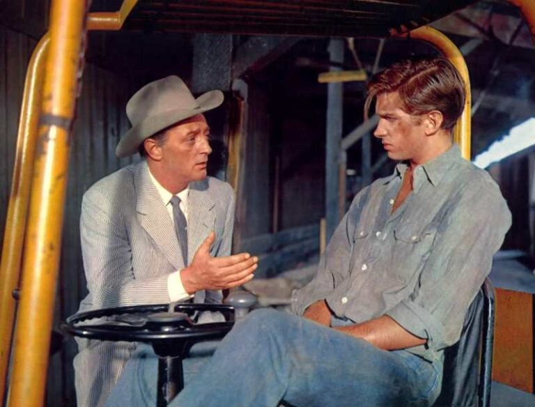 Robert Mitchum conversa com George Hamilton em cena de "Herança da Carne"