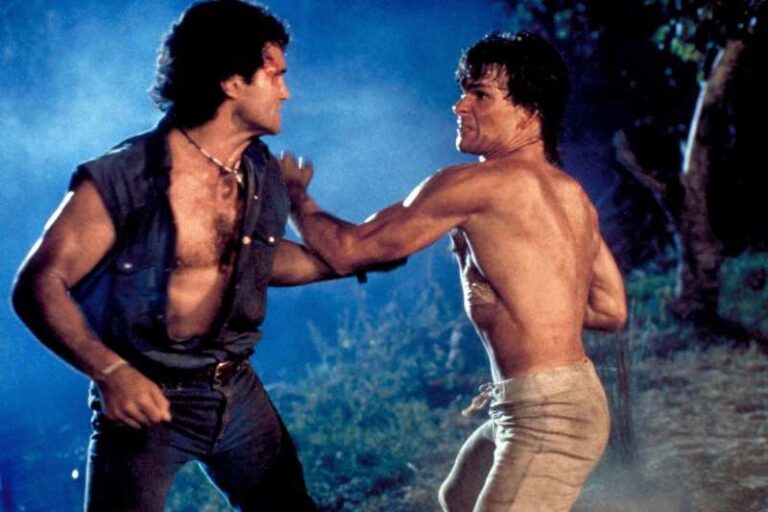 Um homem com colete de jeans e outro sem camisa lutando.