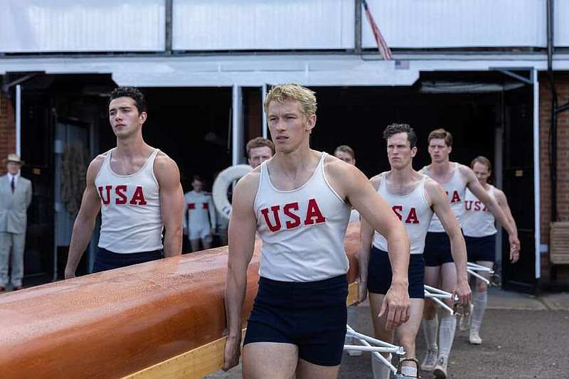 Atletas do time estadunidense de remo carregando um barco.