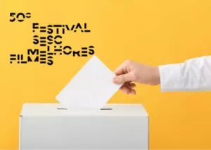 Uma mão depositando voto na urna