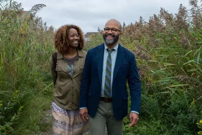 Um casal caminha por um jardim sorrindo.